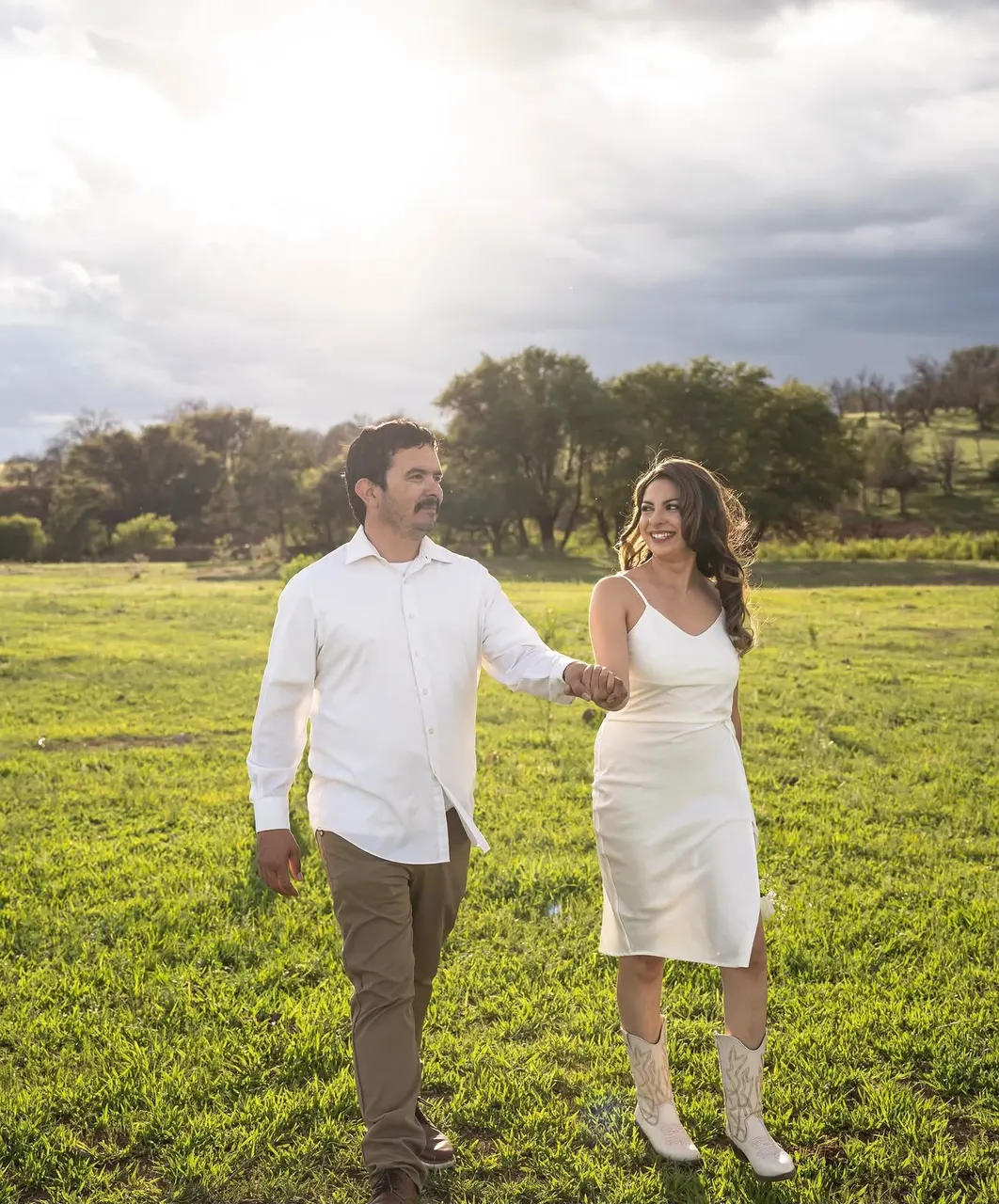 La pareja caminando en el campo a contraluz