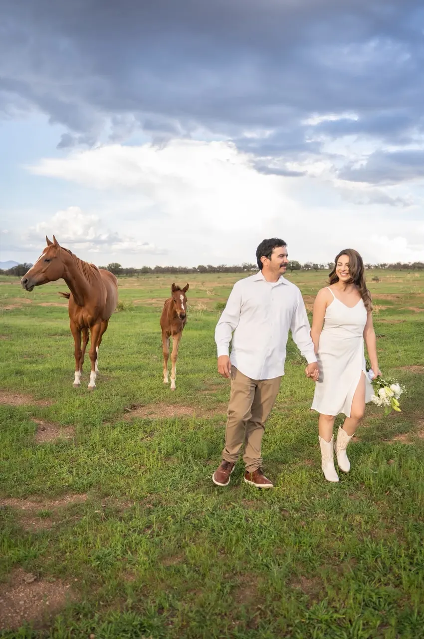 Analhy y Alejandro caminando junto a una yegua y su potrillo